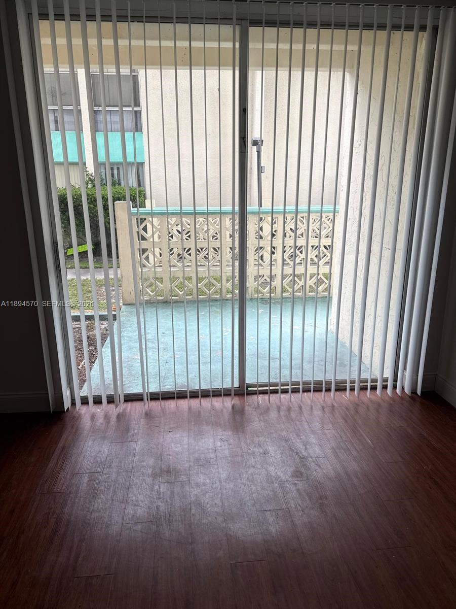 2029 Northwest 46th Avenue, Unit E107 Lauderhill, FL 33313 - Photo 4 of 12 a view of an empty room with wooden floor and a window