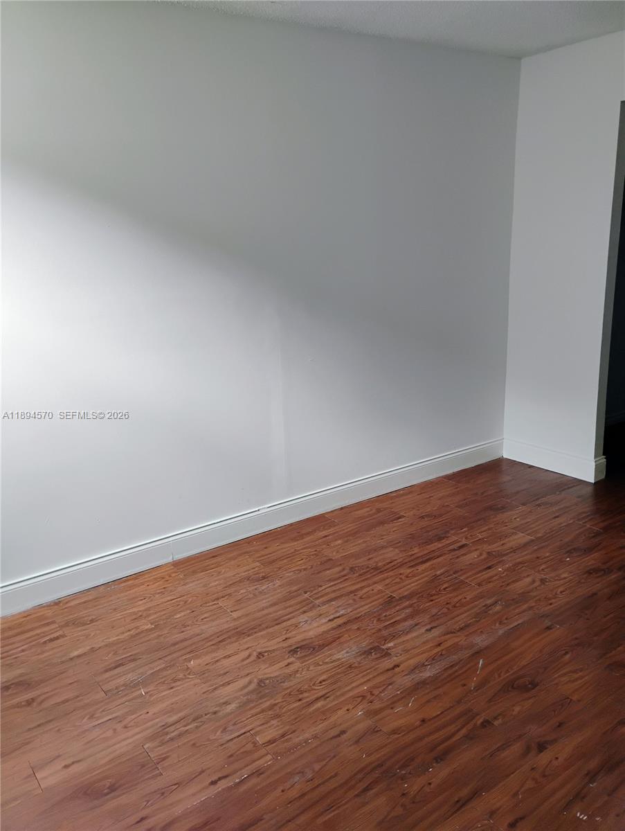 2029 Northwest 46th Avenue, Unit E107 Lauderhill, FL 33313 - Photo 8 of 12 a view of an empty room with wooden floor
