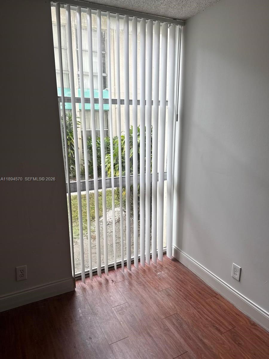 2029 Northwest 46th Avenue, Unit E107 Lauderhill, FL 33313 - Photo 9 of 12 an empty room with wooden floor and windows