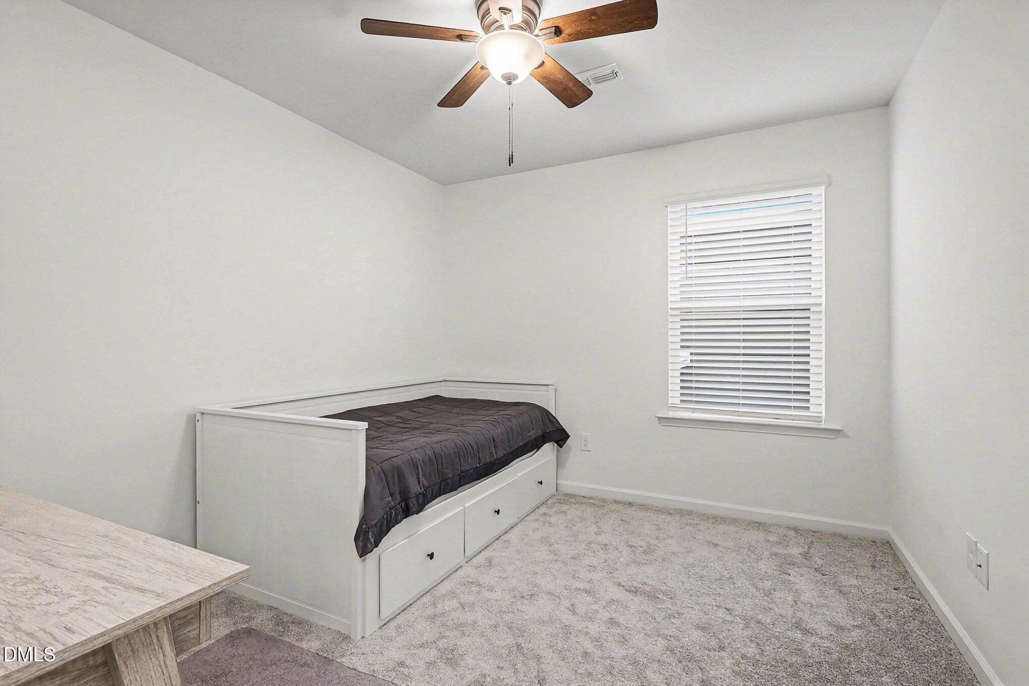 2732 Princess Tree Drive Raleigh, NC 27616 - Photo 20 of 32 a room with a bed and a chandelier fan