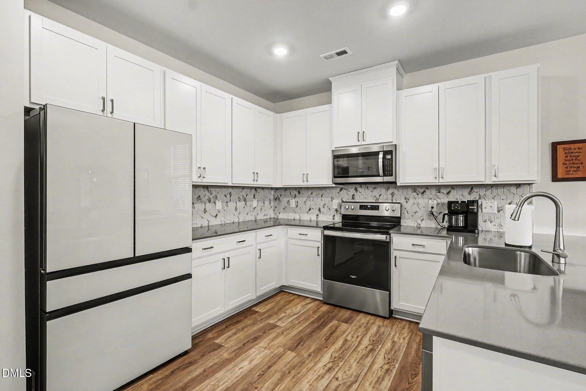 2732 Princess Tree Drive Raleigh, NC 27616 - Photo 7 of 32 a kitchen with granite countertop white cabinets and stainless steel appliances