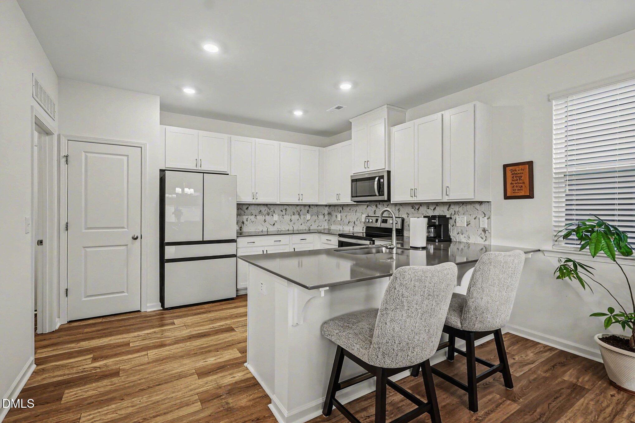 2732 Princess Tree Drive Raleigh, NC 27616 - Photo 8 of 32 a kitchen with white cabinets and stainless steel appliances