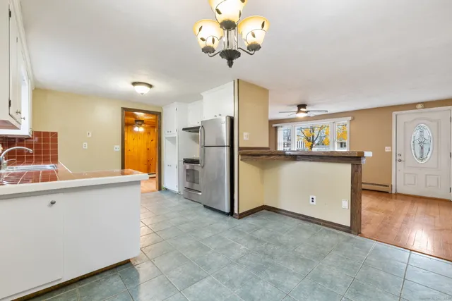 an empty room with wooden floor closet and windows