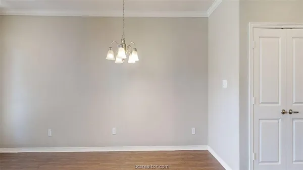 a view of a chandelier in big room with wooden floor