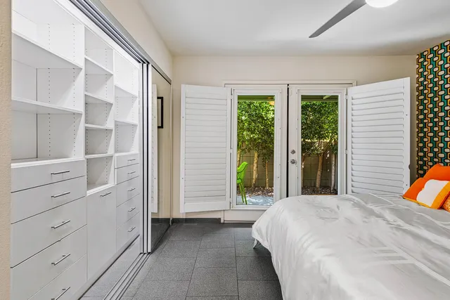 a large white bedroom with a large bed and a large window