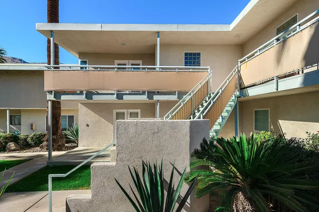 a view of a building with a plants and a table and chair