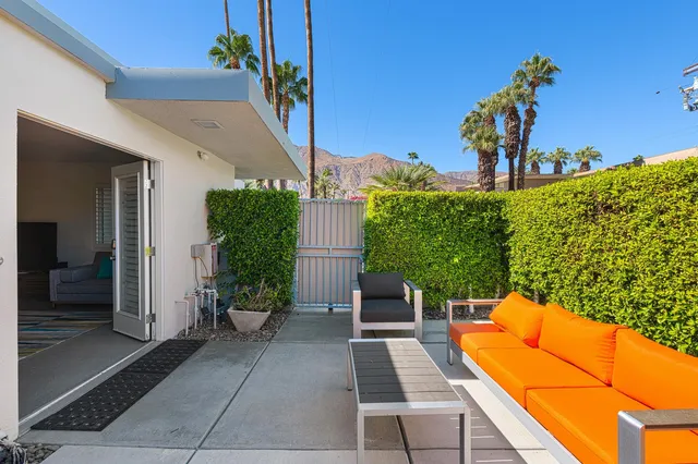 a view of a chairs and table in the patio with a backyard