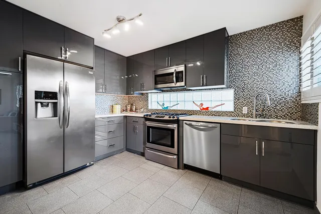 a kitchen with stainless steel appliances granite countertop a refrigerator and a sink