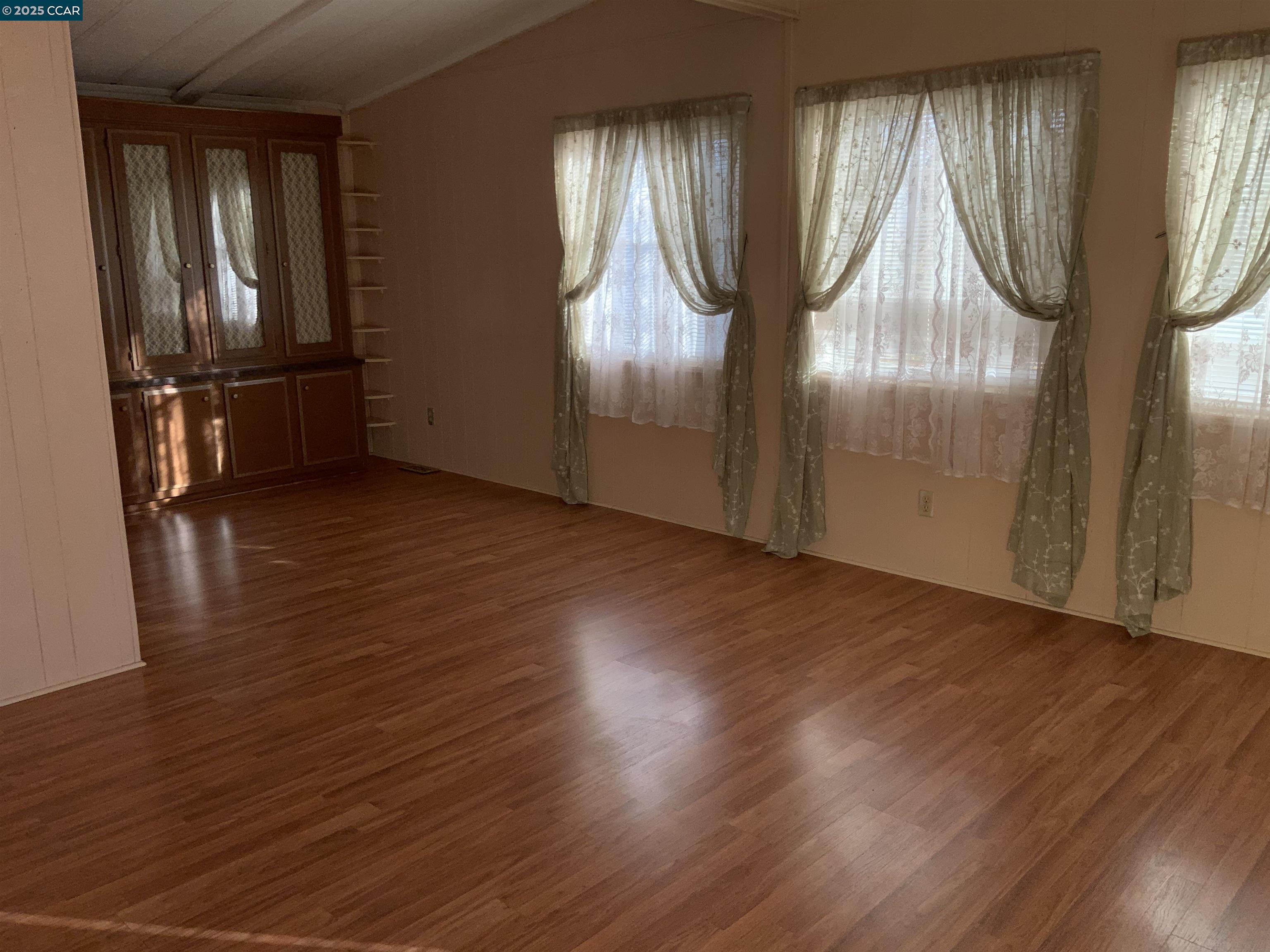 202 Queens Way Pittsburg, CA 94565 - Photo 8 of 29 an empty room with wooden floor and windows