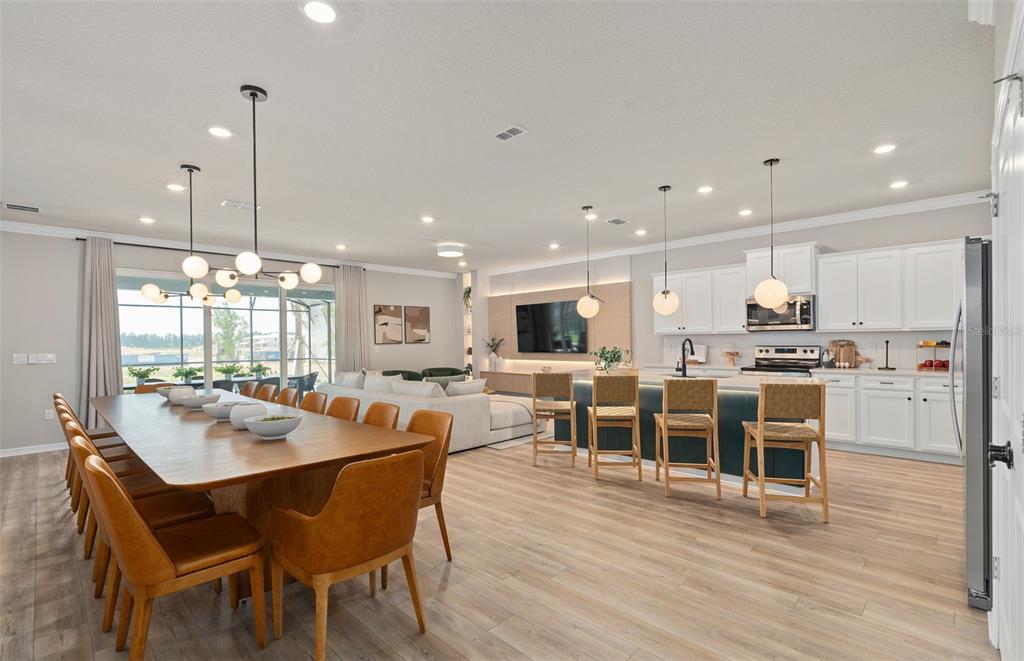 15918 Calm Key Loop Clermont, FL 34714 - Photo 13 of 57 a dining room with stainless steel appliances kitchen island granite countertop a dining table chairs and view living room