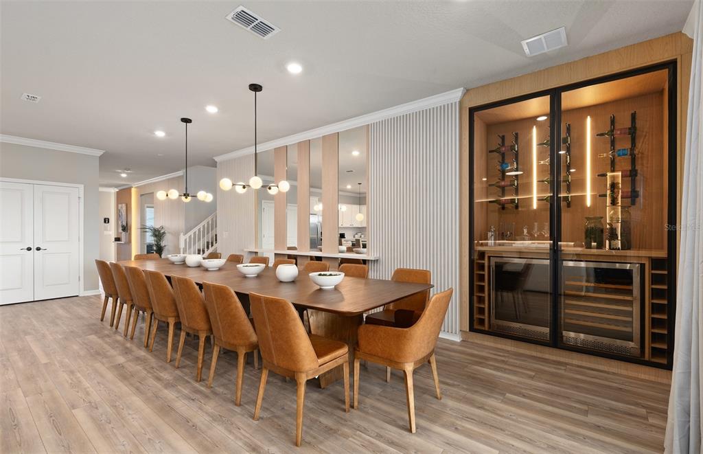 15918 Calm Key Loop Clermont, FL 34714 - Photo 15 of 57 a dining hall with stainless steel appliances kitchen island granite countertop a table chairs and a wooden floor
