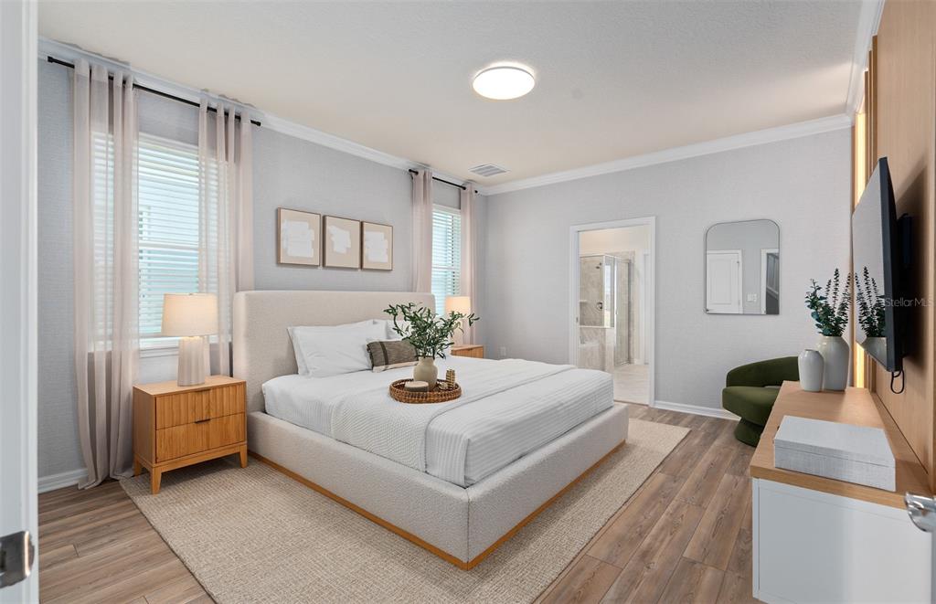 15918 Calm Key Loop Clermont, FL 34714 - Photo 23 of 57 a bedroom with a bed a mirror and a flat screen tv