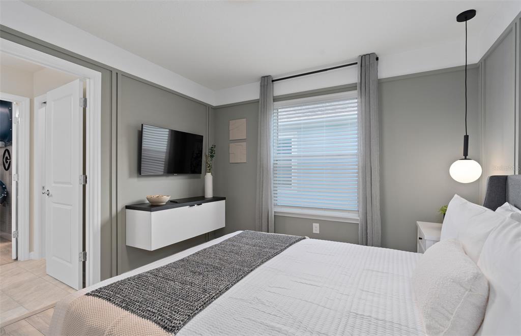 15918 Calm Key Loop Clermont, FL 34714 - Photo 43 of 57 a bedroom with a bed and a flat screen tv