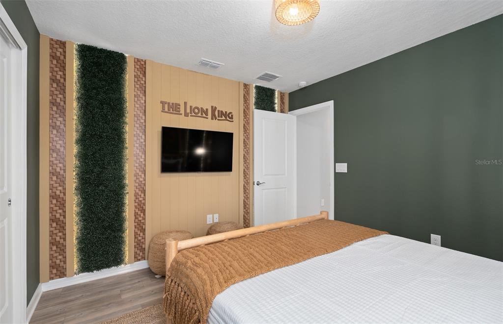 15918 Calm Key Loop Clermont, FL 34714 - Photo 45 of 57 a bedroom with a bed and a flat screen tv