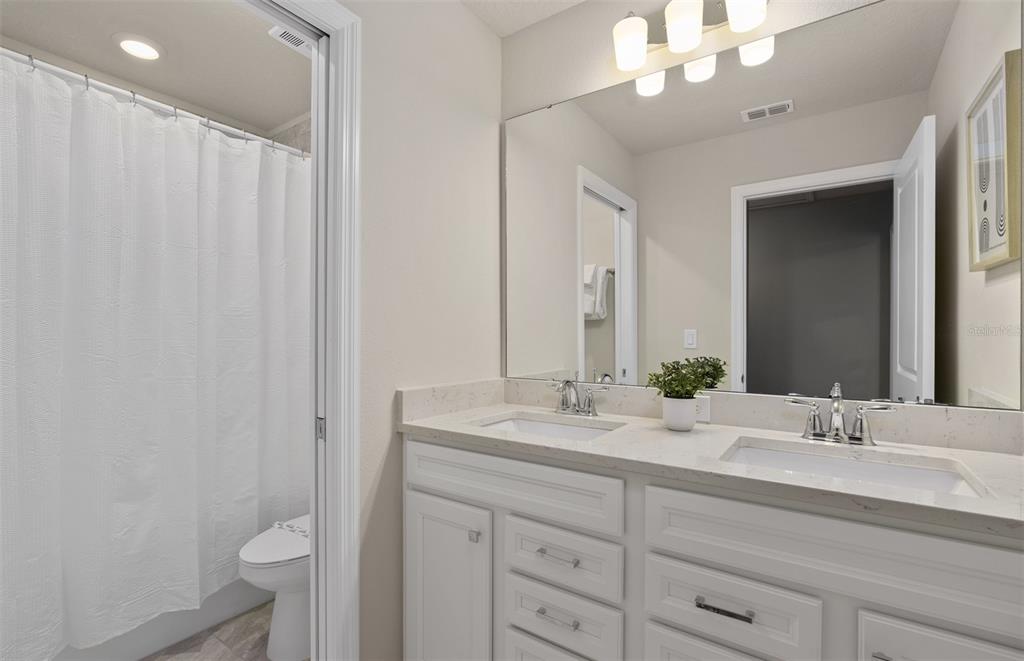 15918 Calm Key Loop Clermont, FL 34714 - Photo 46 of 57 a bathroom with a double vanity sink and a mirror