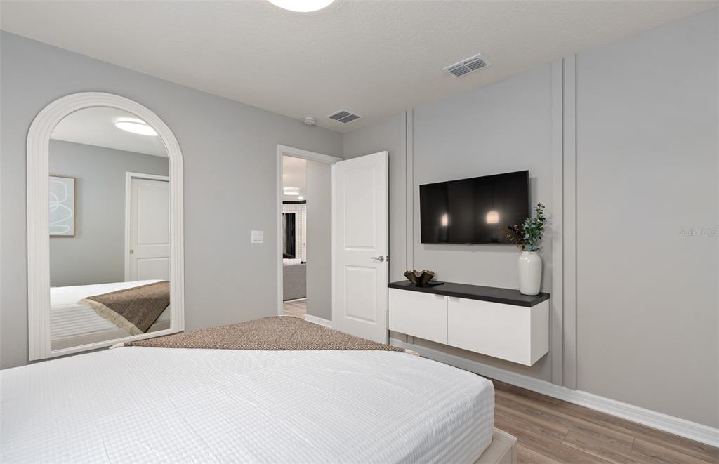 15918 Calm Key Loop Clermont, FL 34714 - Photo 48 of 57 a bedroom with a bed and a flat screen tv