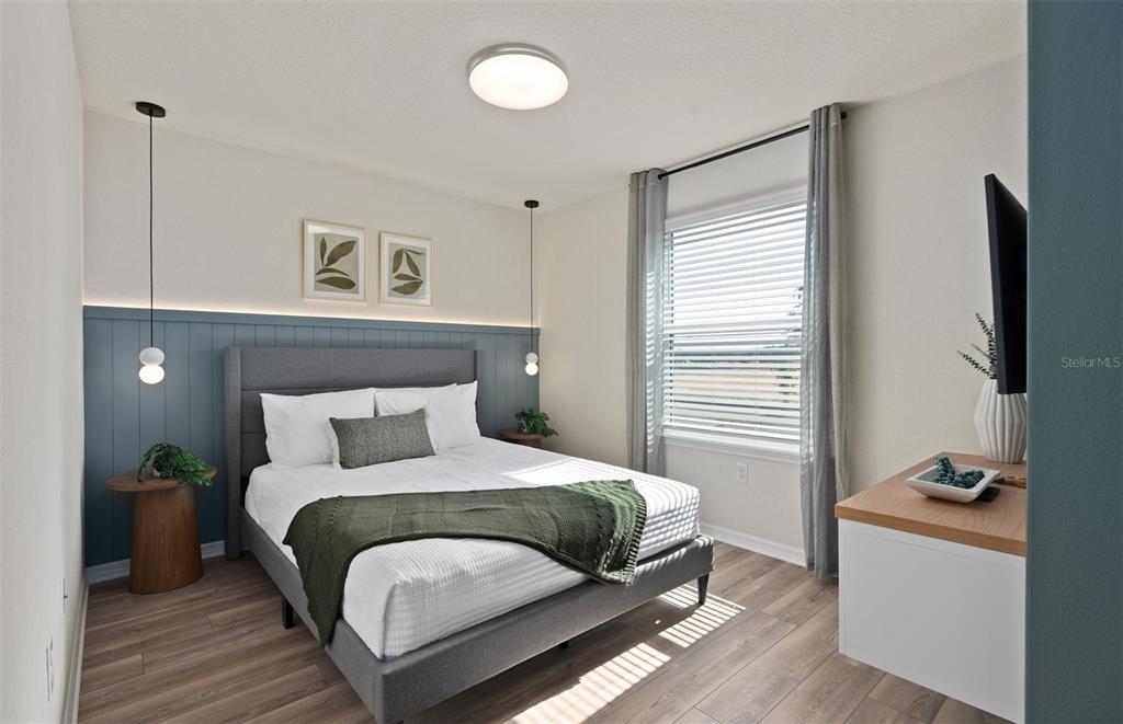 15918 Calm Key Loop Clermont, FL 34714 - Photo 52 of 57 a bedroom with a bed and a flat tv screen on dresser