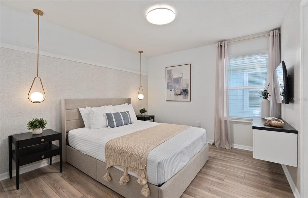 15918 Calm Key Loop Clermont, FL 34714 - Photo 55 of 57 a bedroom with a bed and a flat tv screen on the dresser