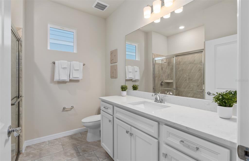 15918 Calm Key Loop Clermont, FL 34714 - Photo 8 of 57 a bathroom with a sink a toilet and a large mirror