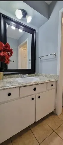 a bathroom with a granite countertop sink and a mirror