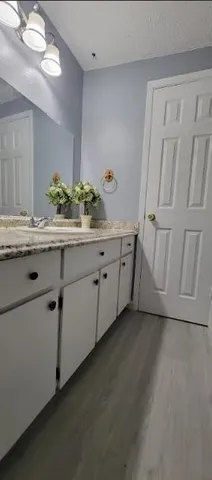 an empty room with wooden floor and a ceiling fan