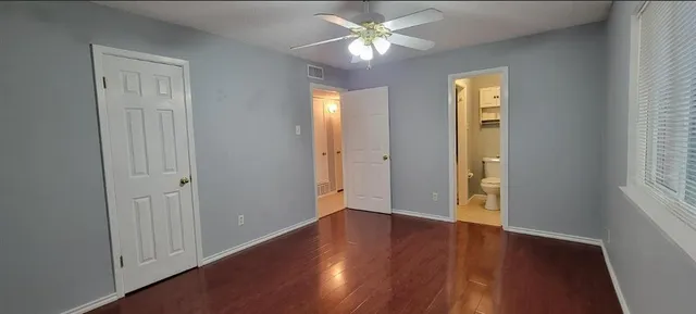 an empty room with a window and a fan
