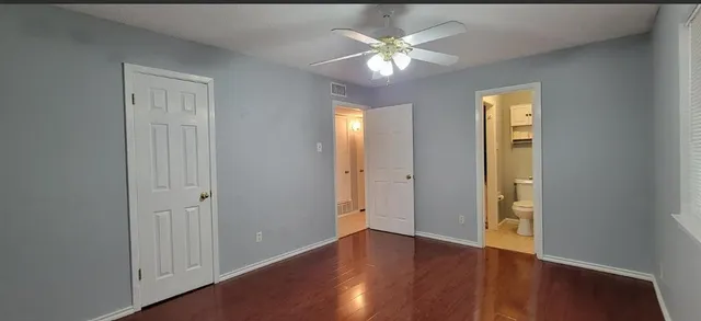 an empty room with closet and a chandelier fan