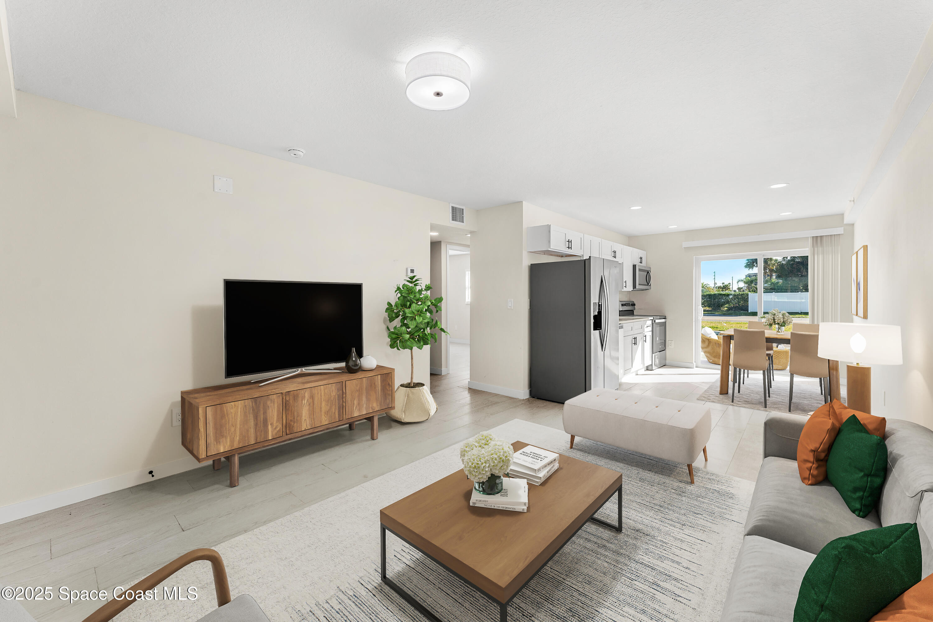 122 Central Road, Unit 101 Indian Harbour Beach, FL 32937 - Photo 7 of 14 a living room with furniture and a flat screen tv