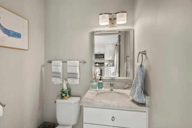 a bathroom with a granite countertop sink a toilet and a mirror