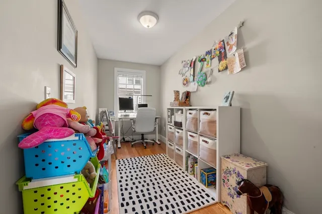 a room with furniture a rug toys and a window