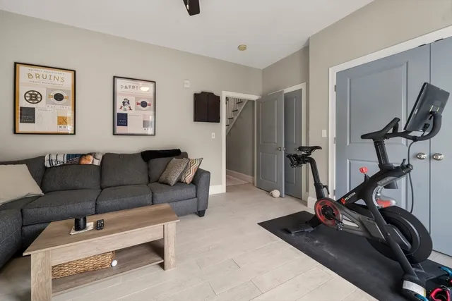 a living room with furniture a flat screen tv and a window