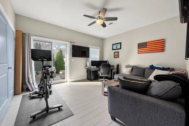 a living room with furniture gym equipment and a flat screen tv