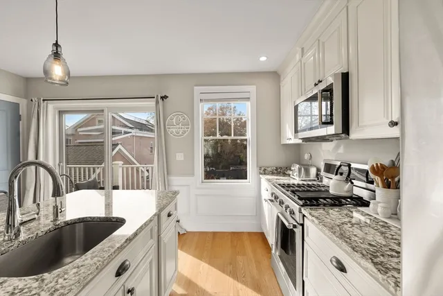 a kitchen with granite countertop a sink and a stove top oven