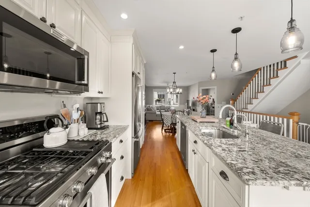 a kitchen with lots of counter top space a stove and wooden floor