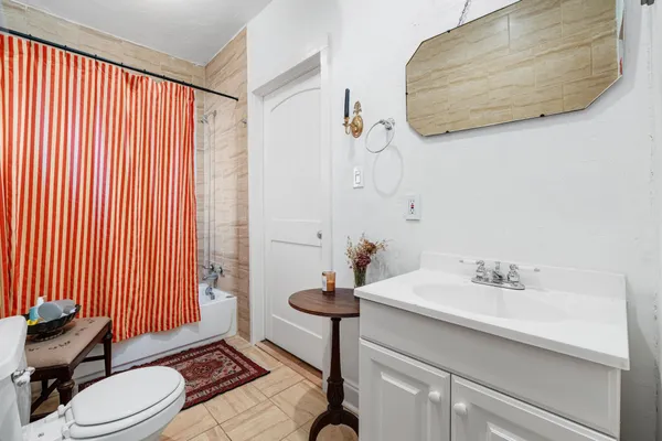 a bathroom with a sink a toilet and shower curtain