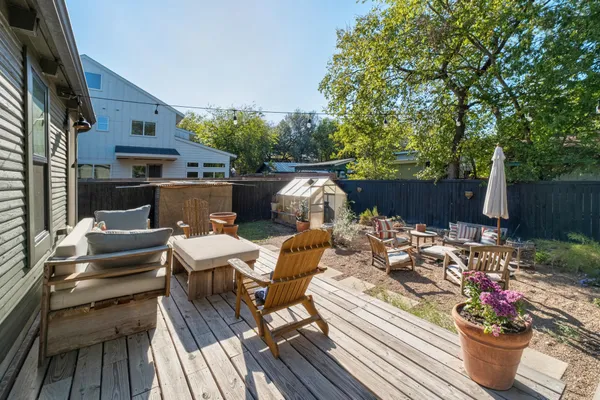 a view of a patio with couches table and chairs and potted plants
