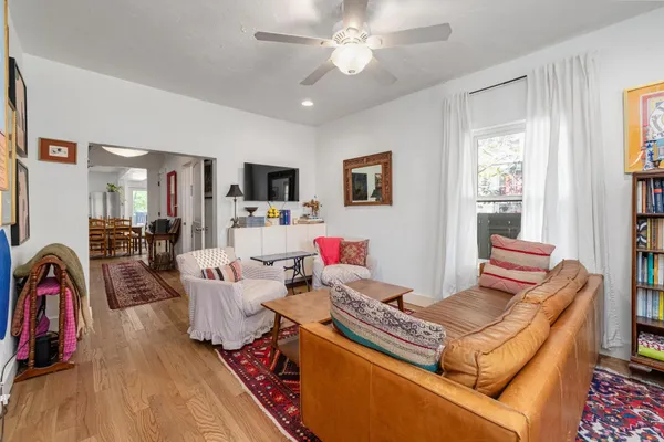 a living room with furniture kitchen view and a window