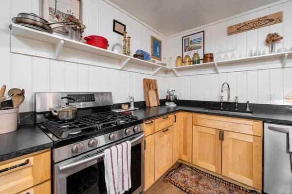 a kitchen with stainless steel appliances a sink stove and cabinets
