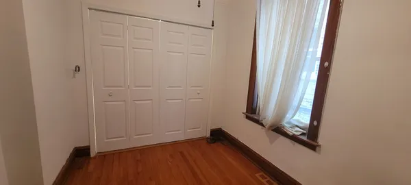 a view of a small space with wooden floor and a window