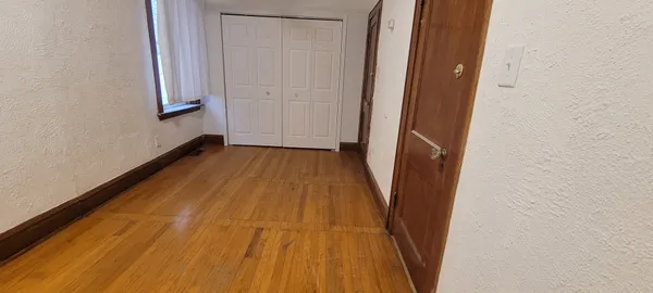 a view of a room with wooden floor and entryway