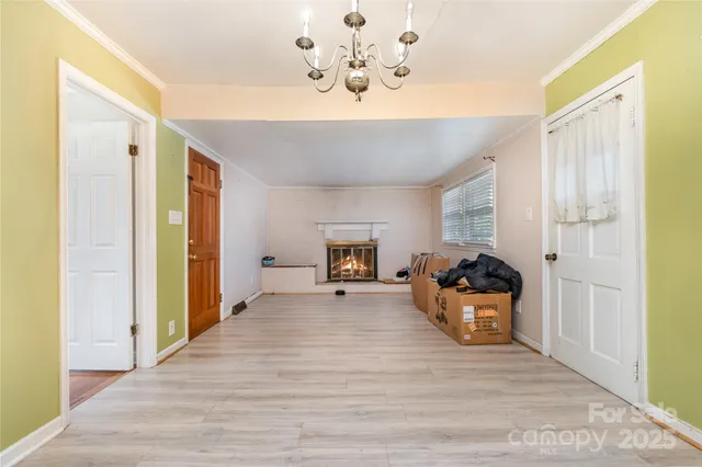 a view of a livingroom with wooden floor and a chandelier