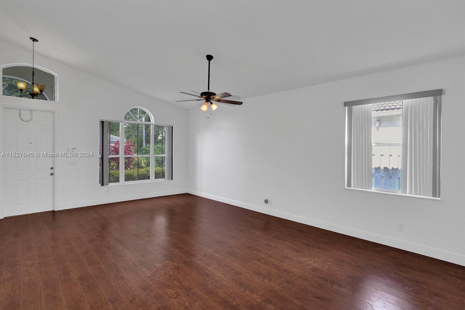 6553 Spring Meadow Drive Greenacres, FL 33413 - Photo 3 of 10 a view of an empty room with window and wooden floor