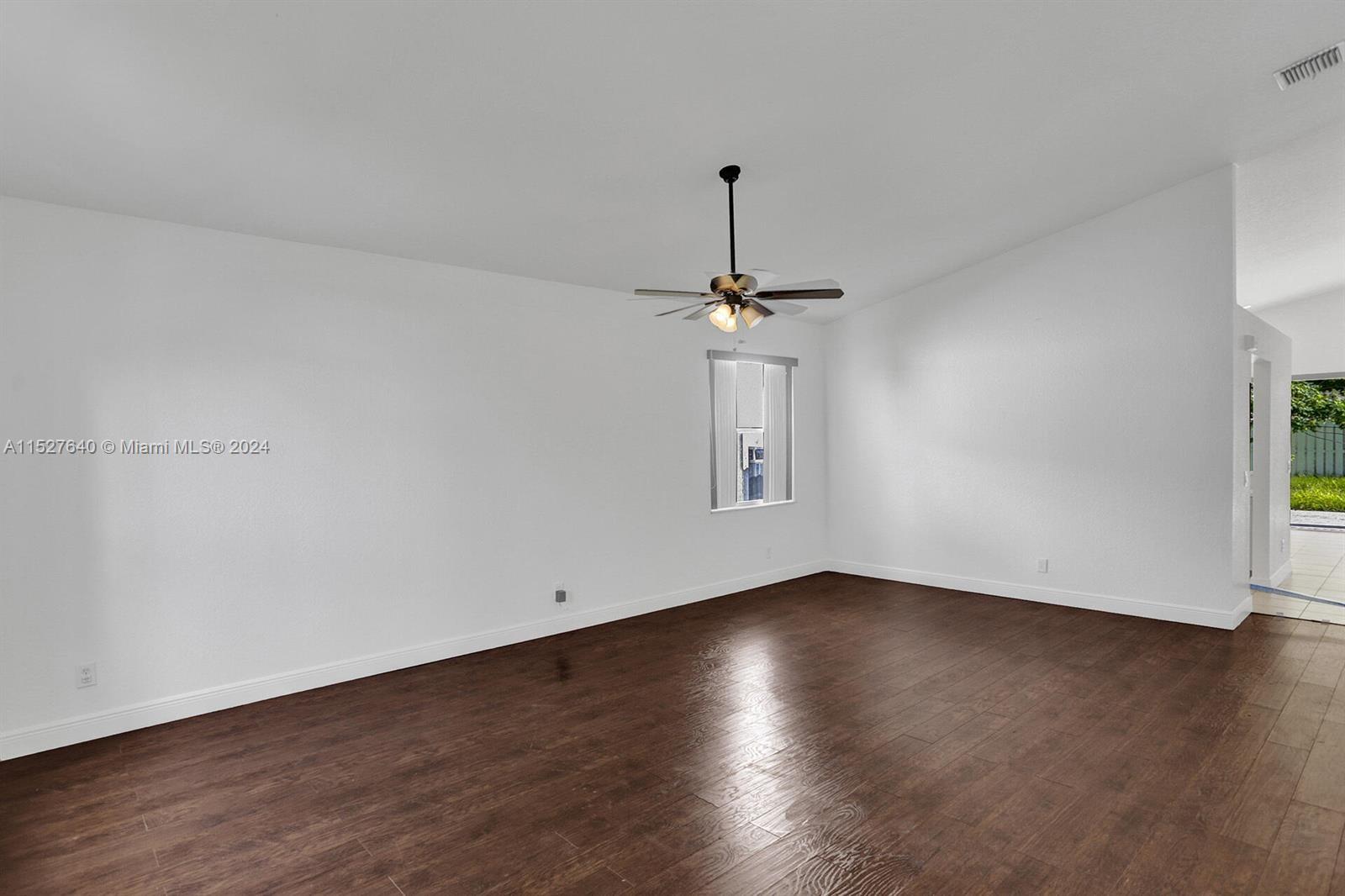 6553 Spring Meadow Drive Greenacres, FL 33413 - Photo 4 of 10 a view of a room with wooden floor and ceiling fan