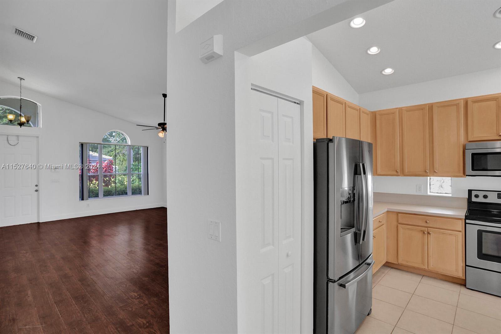 6553 Spring Meadow Drive Greenacres, FL 33413 - Photo 5 of 10 a kitchen with stainless steel appliances a refrigerator and a stove top oven