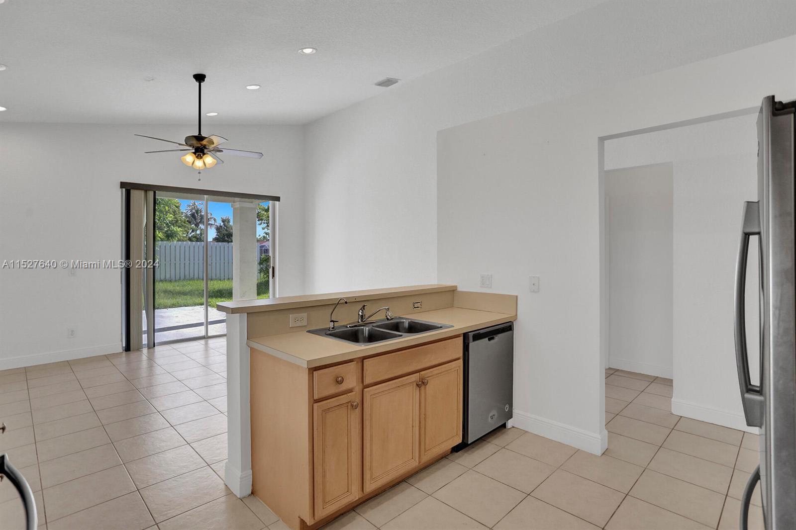 6553 Spring Meadow Drive Greenacres, FL 33413 - Photo 8 of 10 a kitchen with stainless steel appliances granite countertop a stove a sink and a refrigerator