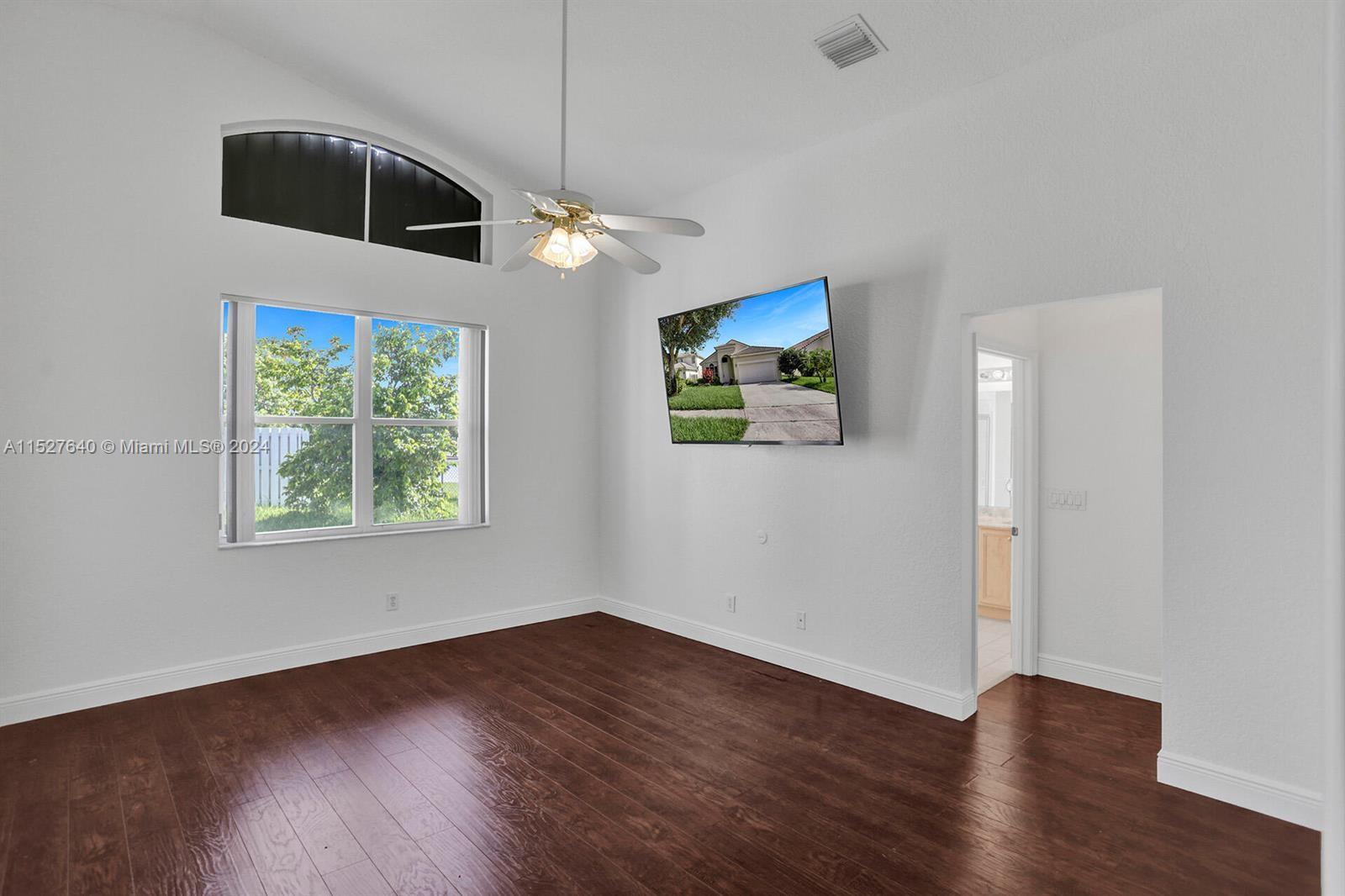 6553 Spring Meadow Drive Greenacres, FL 33413 - Photo 10 of 10 a view of a livingroom with wooden floor ceiling fan and window