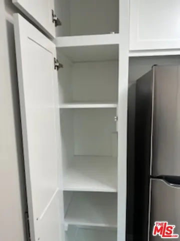 a kitchen with granite countertop white cabinets white appliances and a sink