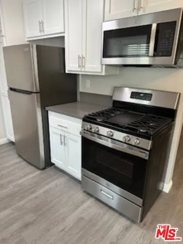 a kitchen with stainless steel appliances granite countertop a stove microwave and refrigerator