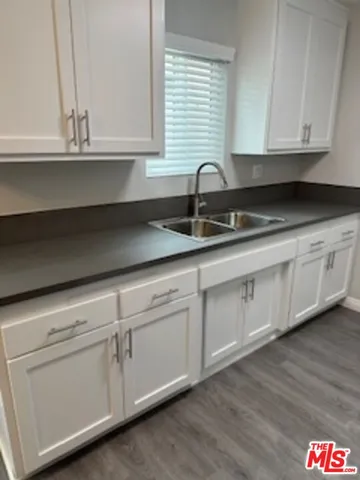 a kitchen with granite countertop white cabinets white appliances and a sink