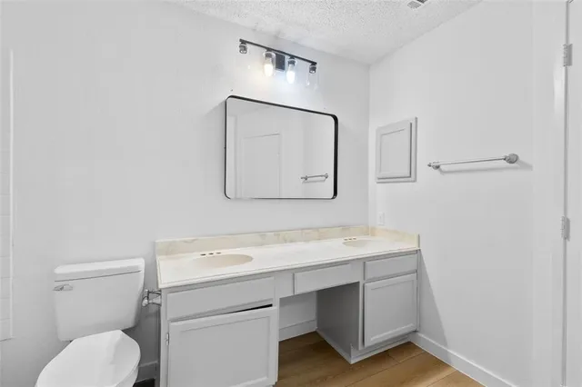 a bathroom with a toilet a sink and mirror